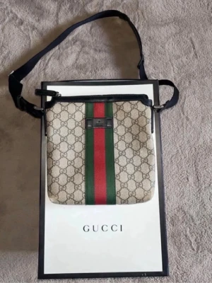 Gucci axelväska GG-mönster - Gucci Crossbody / Axelväska, klassiskt GG-monogram med grön/röd webbdetalj. Väskan är sparsamt använd och i mycket bra skick.  Pris kan diskuteras, tveka ej att skriva vid frågor! 