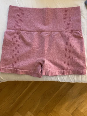 Rosa sömlösa träningstights shorts - Säljer ett par rosa sömlösa shorts Perfekta för träning eller gymmet, stretchigt material som sitter skönt och följsamt. Inga synliga loggor eller märken.