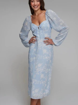 Ljusblå blommig klänning med puffärm - Superfin ljusblå klänning med vita blommor, puffiga långärmar och söt snörning framtill vid bysten. Klänningen har en feminin passform och är vadlång, perfekt för vår och sommar. Tillverkad i ett lätt och luftigt material som känns skönt mot huden. Sparsamt använd. 