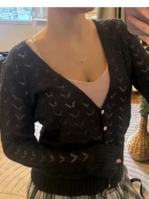 Mohair kofta❤️ - Snygg svart/mörkblå glittrig stickad kofta med v-ringning och vita knappar framtill. Koftan har ett diskret hålmönster och ribbade muddar vid ärmslut och nederkant. Perfekt att slänga över ett linne eller t-shirt för en chill look.