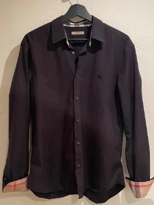 Burberry skjorta  - Svart burberry skjorta i väldigt bra skick utan defekter storlek S. Nypris 5000kr mitt pris är endast 999kr. Hör av er vid frågor. Mvh Luxury closet🙌