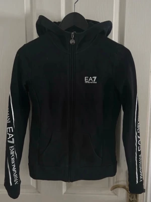EA7 Huvtröja  - Äkta EA7 huvtröja med dragkedja. Använd några gånger men fortsatt i bra skick. Inga slitningar eller skador förekommer. Storlek XXS