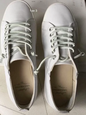 Vagabond vita låga sneakers - Stilrena vita sneakers från Vagabond i lågt snitt. Skorna har vita snören, diskreta sömmar och en klassisk rund tå. Ovandelen är i slätt läder och innersulan är ljusbeige. Perfekta för en clean och enkel look.