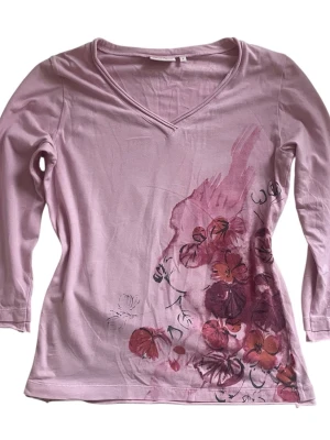 Topp från Jackpot  - Rosa trekvartsärmad topp med blommor och  v-ringning. Har blivit avklippt längst ned samt ärmarna (se bilder) 💗* lätt urtvättad + superlitet hål på baksidan(se bild), märks knappt. Jag brukar ha strl XS/S i toppar för referens!