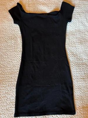 Svart kortklänning - Snygg svart kortklänning med tight passform. Klänningen är enkel och stilren, perfekt för dig som gillar minimalistisk stil. Stretchig och bekväm bomullsklänning.