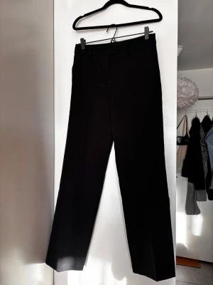 Svarta kostymbyxor från Bik Bok - Snygga svarta kostymbyxor från Bik Bok med raka ben och mid waist. Byxorna har dubbelknäppning med dragkedja och hake. Perfekta för en classy och trendig look. Sitter skitbra men har ett till par så behöver göra mig av med ett par! Har endast använts några få gånger.