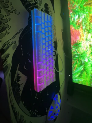RGB mekaniskt tangentbord 60% ATTACKSHARK X68 - Säljer ett kompakt mekaniskt tangentbord med RGB-belysning och unika vita keycaps med mönster. Tangentbordet har 60% layout och ansluts med kabel. Perfekt för gaming eller snygg setup. Tangenterna lyser i flera färger och ger cool effekt på skrivbordet.