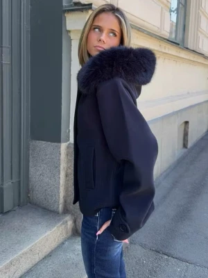  Marinblå kort kappa - Stilren marinblå kappa med stor luva med fuskpäls och raka, vida ärmar. Kappan har knäppning framtill med stora knappar och två fickor. Perfekt för dig som vill ha en trendig och mysig look under kyliga dagar. Storlek 158/164 men passar XXS/XS💙