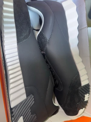 H skor  - Snygga svarta sneakers med chunky, räfflad vit sula och detaljer i mocka och läder. Storlek 45 passar 44/5 helt nya, samt skickas dagen du köper