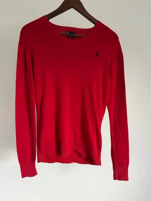 Polo Ralph Lauren Stickad - Polo Ralph Lauren Stickad Storlek: L Passform: Regular Fit Krage: V-ringad Material: Pima-bomull Mått: Bröstvidd 96 cm, längd 62 cm, axel 44 cm Skick: Tröjan är i ett väldigt fint skick utan defekter  Nypris cirka: 800 kr