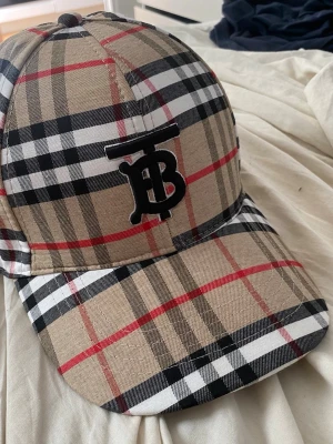 H&M keps  - Rutig keps, andvänd typ 5 gånger utomhus. Har några trådar som är sönder men de går att klippa bort. Det är burberr”y