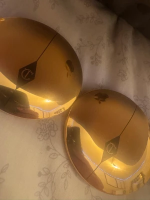 Charlotte Tilbury puderfoundation - Säljer två puderfoundations från Charlotte Tilbury i lyxiga guldfärgade, runda dosor med spegel. Perfekt för en naturlig finish och enkel att ta med i väskan. Produkten har en pressad puderformula och elegant design. Dom är båda använda men det finns fortfarande mycket produkt kvar man får båda för 250