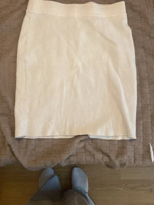 Beige stickad kortkjol - Snygg beige stickad kortkjol med enkel och stilren design. Kjolen har rak passform och är tillverkad i ett mjukt stickat material som känns skönt mot huden. Perfekt att matcha med en oversized tröja eller en cool t-shirt.