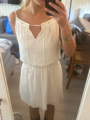 Vit kort klänning med snörning - Vit klänning från GUESS, storlek S. I mycket bra skick!