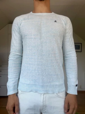 Ljusblå och vit tröja - Ljusblå och vit tröja från märket Khujo. Tillverkad i 100% bomull. Strl S. Inga defekter. Modellen är 178 cm och väger 77 kg. Hör gärna av dig vid frågor!