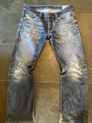 Blå slitna jeans från Diesel - Säljer ett par riktigt feta vintage diesel jeans med sjuk tvätt/slitningar. De är i modell Larke (regular-straight) och storlek W32 L32.   100% bomull  Mått: ytterbenslängd: 99cm, innerbenslängd: 72cm, Midja: 45cm, Benöppning: 22cm                                               