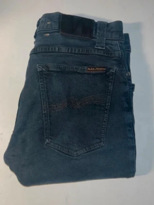 Nudie jeans  - Säljer ett par jeans från Nudie Jeans med skinny passform. Obs jeansen är uppklippta, har ett hål i grenen och tyget har skrynklats (se bilder). Midja 35cm, längd 98cm. JAG SKICKAR EJ FLER BILDER NÄR JAG BÄR JEANSEN! för bättre inblick i passformen rekommenderar jag att googla på modellnamnet. För storleksguide kolla måtten noggrant då jeansen alltid kan vara uppsydda heller krympta och jag ej tar emot returer :) s5,1