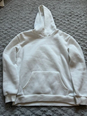 Vit hoodie med fjärilstryck - Säljer en vit hoodie med stor färgglad fjäril och texten 'Transformed by yourself' på ryggen. Hoodien har huva, magficka och ribbade muddar. Materialet ser ut att vara mjukt och bekvämt, perfekt för chill dagar. Den har ingen lapp i sig men jag vet att den är från SHEIN och är i one sise,