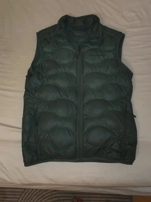 Peak Performance väst - Snygg mörkgrön dunväst. Verkar vara rätt ovanlig då jag aldrig sett just den här västen nånstans. Litet hål på baksidan men annars bra skick.