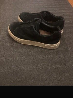 Svarta slip-on sneakers i mocka, eytys doja  - Stilrena svarta slip-on sneakers med ovandel i mocka och vit, tjock sula. Skorna har en enkel och clean design utan snörning, vilket gör dem lätta att ta på. Passar perfekt till en avslappnad streetwear-look.