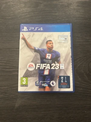 FIFA 23 till PS4 - FIFA 23 till PlayStation 4 med originalfodral och skiva. Omslaget har en sportig design med fotbollsspelare i blått matchställ. Spelet är ett fotbollsspel där du kan bygga ditt drömlag och tävla i olika ligor. Perfekt för dig som gillar sport och gaming.