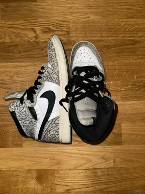 Air Jordan 1 High White Cement - Säljer ett par Air Jordan 1 High ”White Cement” i toppskick då lillebrorsan vuxit ur dem. De är sparsamt använda, helt luktfria och väl omhändertagna så inga slitna skor som kastas bort utan ett par skor som tjänat sitt syfte som förtjänar en ny ägare!!  Lillebrorsan brukade skryta om hur mycket blickar och komplimanger han fick med skorna på de fick synd att han växte ur dem:(  (OBS annan skokartong följer med)!