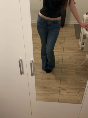 Blå bootcut jeans från Vero Moda - Säljer ett par blå bootcut jeans från Vero Moda som inte längre kommer till användning. Jeansen är lågmidjade och stretchiga. Fint skick!