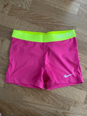 Rosa Nike Pro Shorts - Nike Pro shorts. Släppt lite i trycket, se bilder. Annars fina.