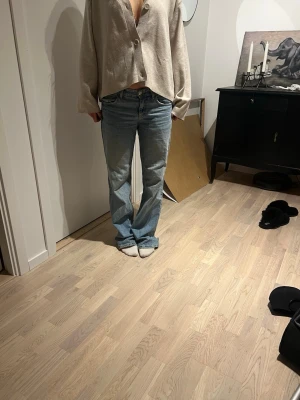 Ljusblå baggy jeans - Säljer ett par ljusblå jeans med rak passform och klassisk femficksdesign. Jeansen har normal/låg midja och stängs med dragkedja och knapp. Perfekta för en avslappnad och trendig look.