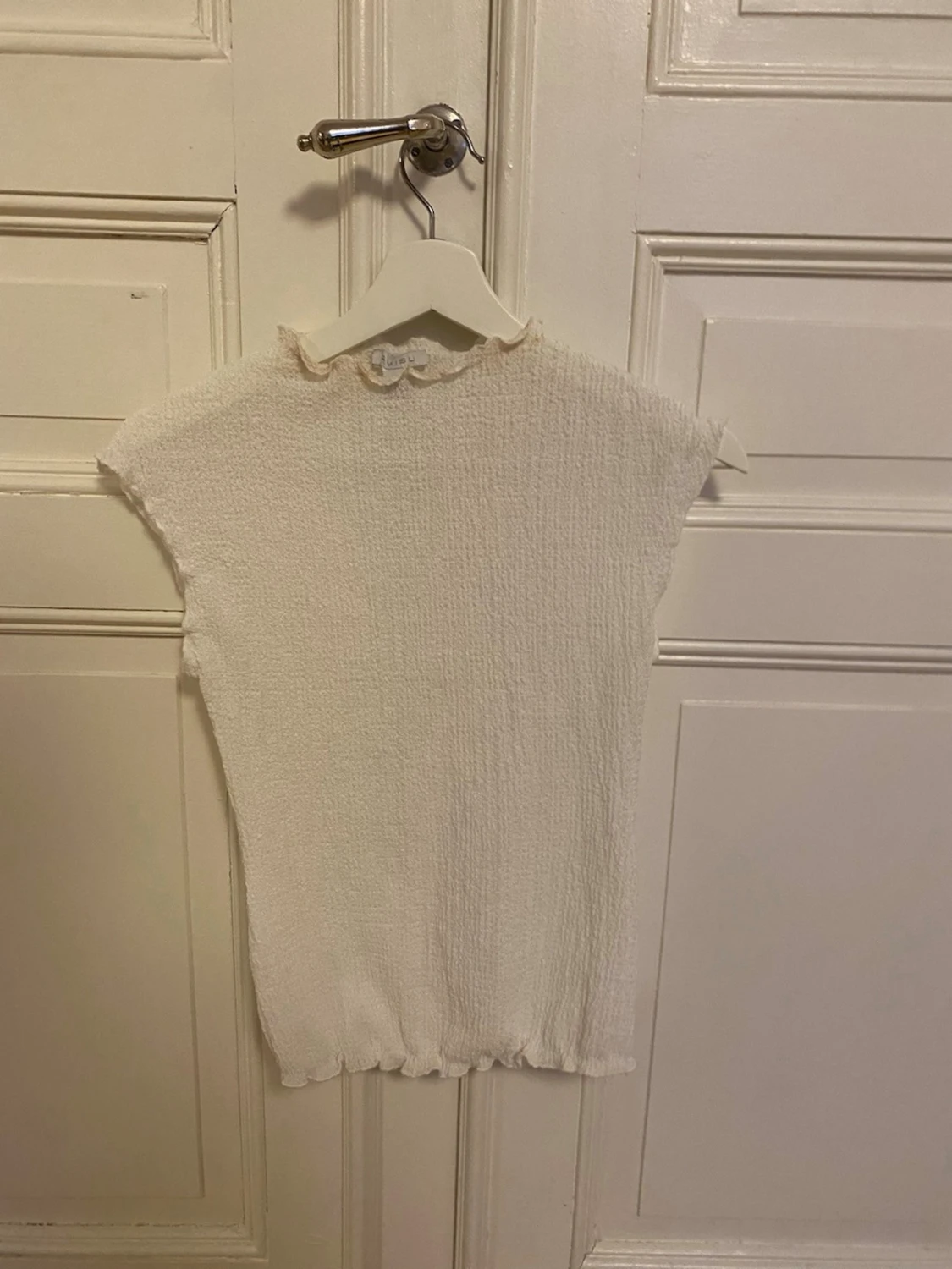 Vit ribbad topp med volangkant