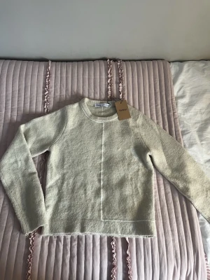 Cremevit stickad  tröja från Zara - Snygg och trendig beige stickad tröja från Zara med rund halsringning och långa ärmar. Tröjan är i storlek S men sitter som XS, tröjan är köpt på Sellpy men aldrig använd då den inte passa mig! 💞