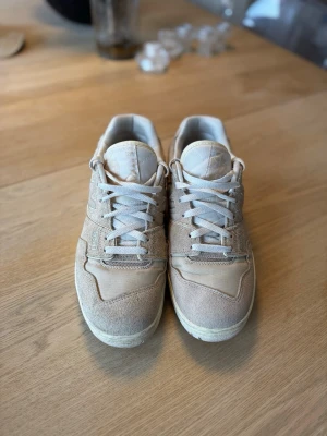Aimé Leon Dore x New Balance  - Stilrena sneakers från Aimé Leon Dore i beige mocka och textil. Skorna har klassisk låg profil, vita snören och diskret logga på sidan. Perfekta för en clean och avslappnad look. Nypris 2560kr