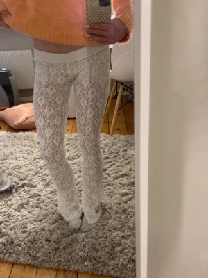 Vita spets byxor  - Säljer ett par vita stretchiga leggings i spets och vida ben. Byxorna är ifrån Zara och har passar till många olika outfits och stilar. 