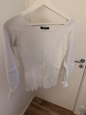 Vit ribbad topp från Gina Tricot - Säljer en vit långärmad topp från Gina Tricot. Toppen är ribbad och har en bred, rundad halsringning. Passar mig som har S