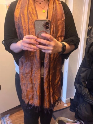 Brun paisleymönstrad halsduk från Kina  - Vacker sjal med ett paisley-liknande mönster och fransar. En brun sjal förmodligen från Kina. Längd är 180,5 cm. Bredd 54 cm. Hämtas på Södermalm i Stockholm eller skickas till dig. Med vänlig hälsning, Fanny