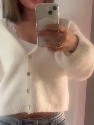 Vit kofta från H&M med pärlemorknappar - Mysig vit kofta från Gina med pärlemorknappar framtill. Koftan är stickad, har en croppad passform och långa ärmar. Perfekt att slänga över ett linne eller t-shirt för en chill look.