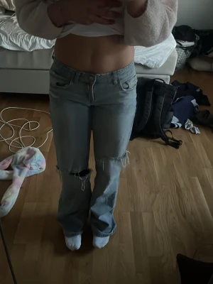 Ljusblå slitna bootcut jeans - Säljer ett par ljusblå jeans med bootcut passform och slitna detaljer vid knäna. Änvänt dom få gånger säljer för jag inte gillar hur dom sitter på mig kan diskutera pristet och kan posta inom snabbt dagar efter köp 🥰