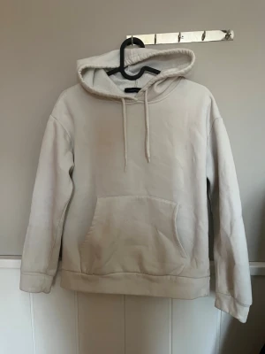 Vit hoodie från Atmosphere XS - Klassisk vit hoodie från Atmosphere i storlek XS. Hoodien har huva med dragsnören och en stor känguruficka framtill. Mjuk insida och enkel design som passar till det mesta. Perfekt för en avslappnad stil.