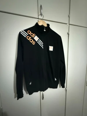 Svart Adidas track jacket med tryck - Använd. Säljs enligt bilder. Storlek S