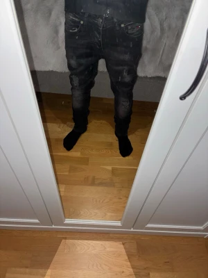Svarta slim fit jeans med slitningar pris kan diskuteras  - Säljer ett par svarta Tommy hilfigher jenas, slim fit med coola slitningar och blekta detaljer på benen. Jeansen har klassisk femficksdesign och knapp gylf. Sitter skönt och är riktigt snygga och smidiga. Pris kan diskuteras 