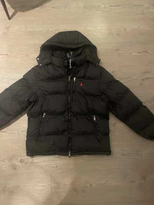 Ralph Lauren jacka  - Snygg svart pufferjacka från Ralph Lauren med röd logga på bröstet. Riktigt najs jacka! Skriv vid funderingar, buda gärna 