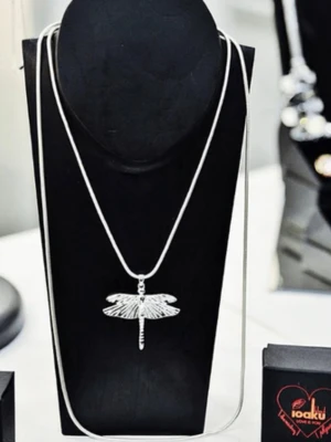 Silverhalsband med trollslända från Ioaku - Snyggt halsband i silverfärg från Ioaku med ett detaljerat trollslände-hänge. Kedjan är tunn och smidig, och hänget har en blank finish som ger ett stilrent intryck. Perfekt för dig som gillar naturinspirerade smycken och vill ha något unikt.