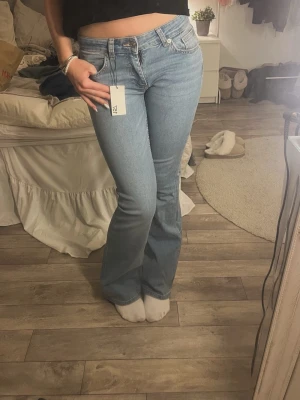 Ljusblå bootcut jeans - Snygga ljusblå bootcut jeans från Lager 157 med klassisk femficksdesign och lägre midja. Jeansen har en lätt utsvängd passform nertill och stängs med dragkedja och knapp. Perfekta för en trendig och avslappnad look. Storlek S full length