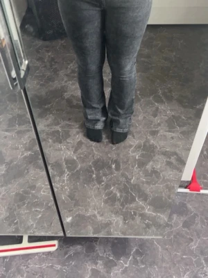 Grå bootcut jeans med tvättad look - Säljer ett par grå bootcut jeans med tvättad effekt. Jeansen har en klassisk femficksmodell och normal midja. Materialet är troligtvis bomull med stretch för skön passform. Perfekta för dig som gillar en avslappnad men trendig stil.