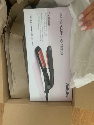 BaByliss Crimper tång svart/roséguld - Säljer en BaByliss Crimper tång  i svart med plattor i roséguld. Perfekt för att skapa volym och textur i håret. Kommer i originalförpackning och har en smidig design med sladd. Enkel att använda för snygga frisyrer. Den är helt ny köpte fel vara så den är fortfarande kvar i förpackningen.