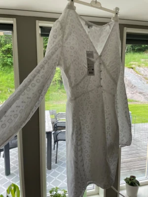 Vit broderad omlottklänning Gina Tricot - Söt vit omlottklänning från Bubbleroom med broderade blommor och v-ringning. Klänningen har långa ärmar och knappar framtill. Perfekt för sommarens alla tillfällen och ger en romantisk känsla med sina fina detaljer. Tyvär va den inte min stil helt🩷HELT NY MEN PRISLAPP 