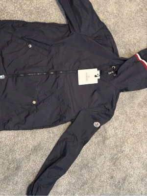 Mörkblå vindjacka från Moncler - Snygg mörkblå vindjacka från Moncler. Storlek S moncler scannen fungerar.