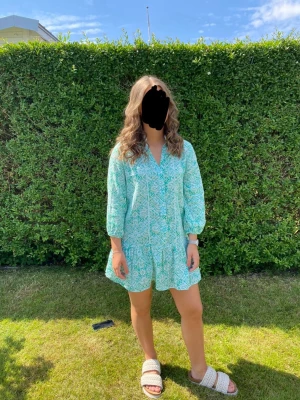 Klänning - Supersöt ljusgrön kortklänning med blommigt mönster och v-ringning. Endast använd en midsommar 