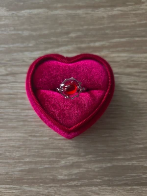Silverfärgad ring med röd sten - ring i storlek 16,1mm, silverfärgad. 