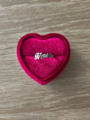 Silverfärgad ring med texten 'Mom' - ring i storlek 19mm, silverfärgad. 